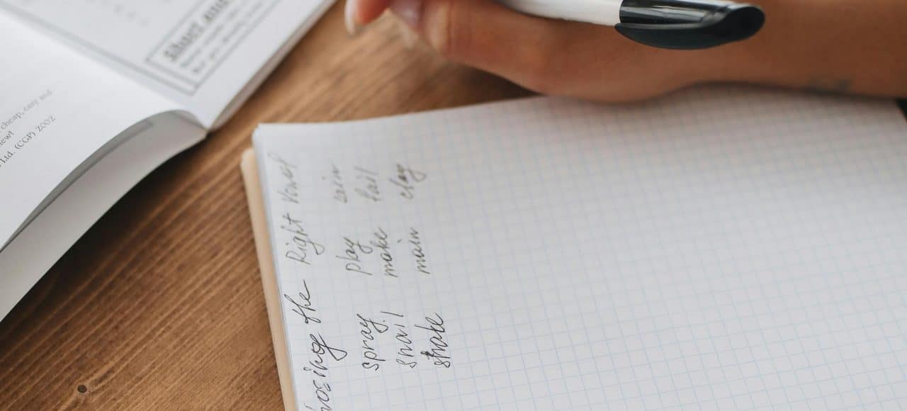 A person takes notes in a notebook, emphasizing study and learning. Ideal for educational themes.